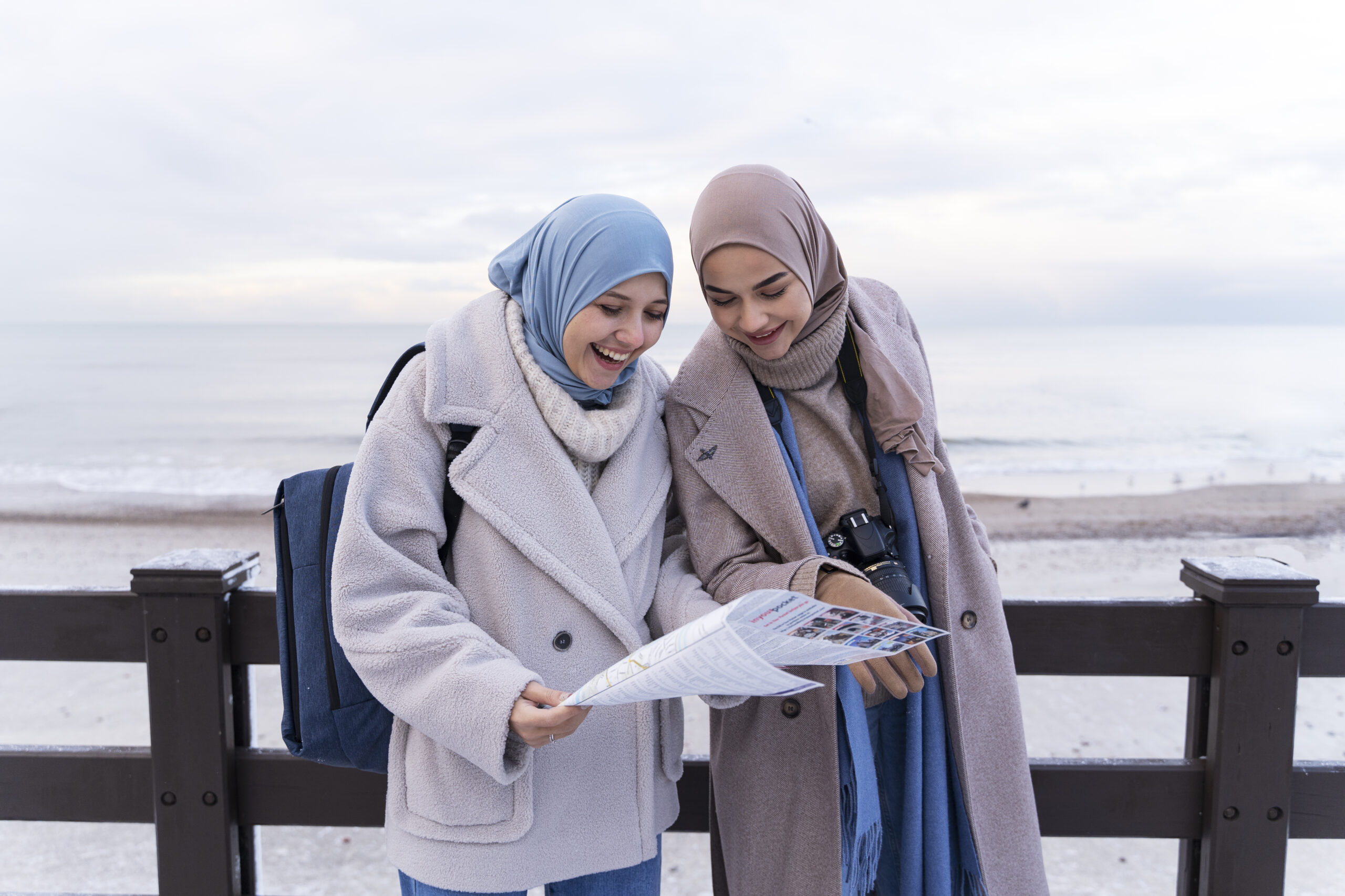 two-muslim-women-with-hijabs-consulting-map-while-traveling