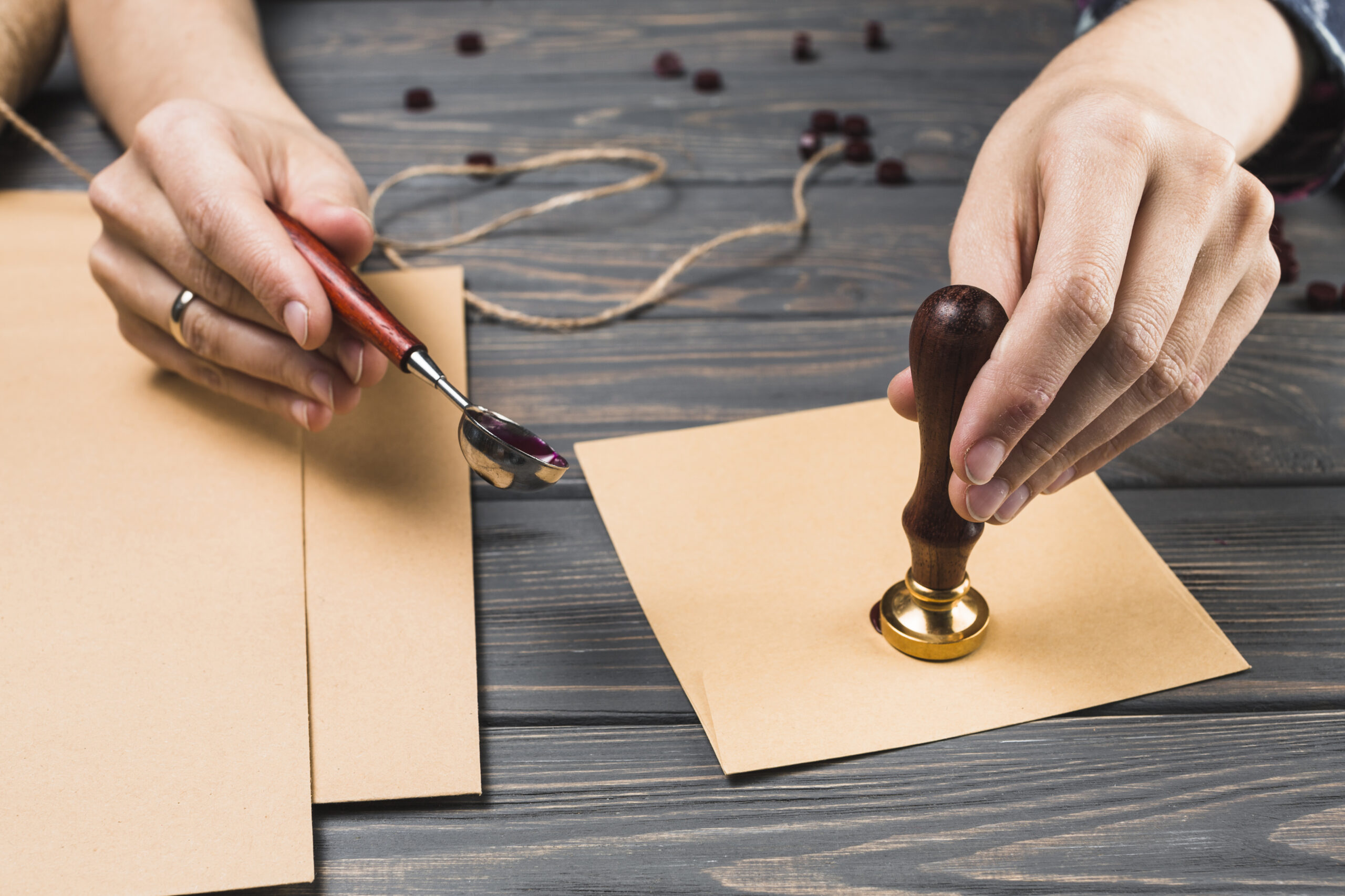 woman-s-hand-sealing-envelope-with-stamp