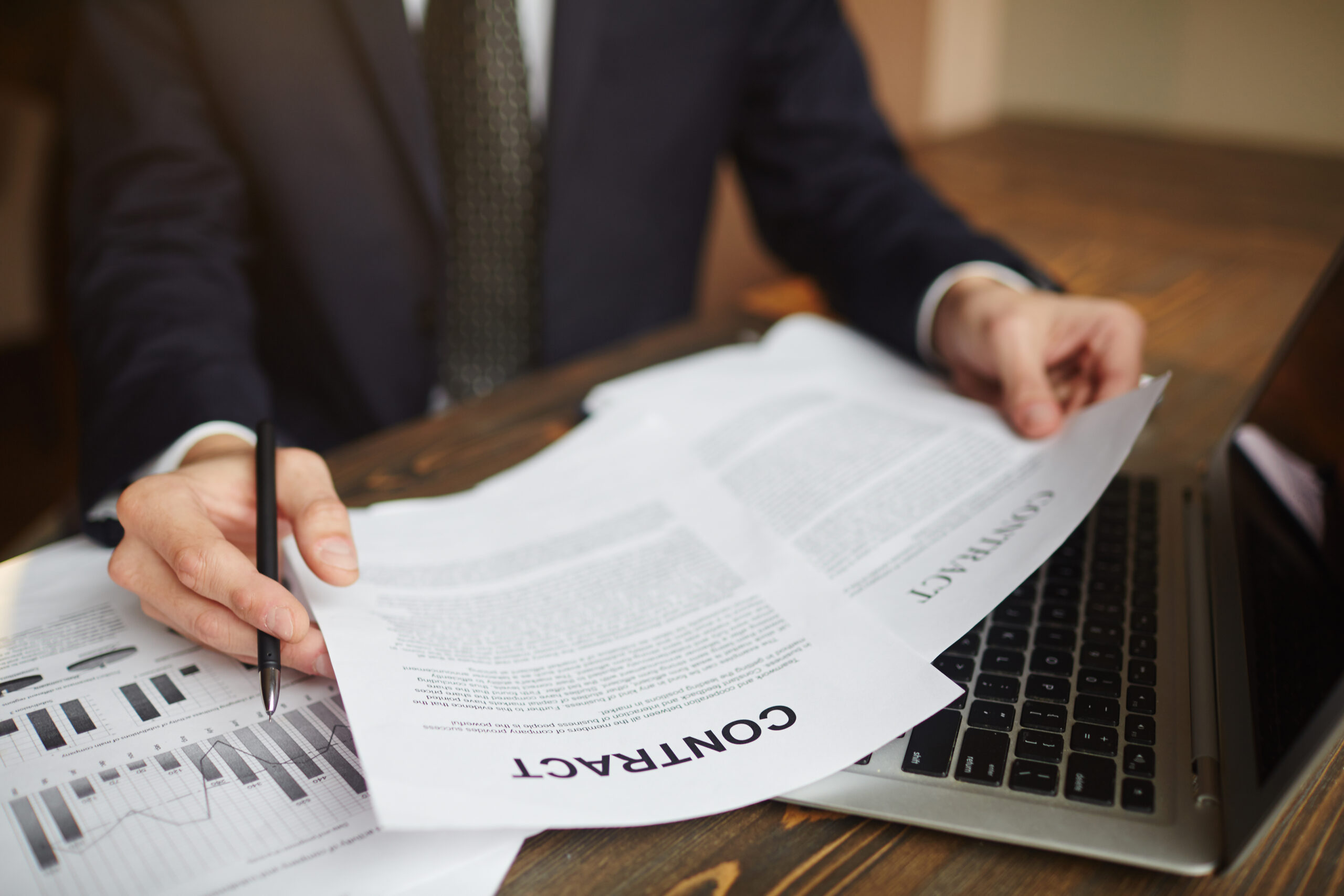Closeup portrait of busy businessman reading contracts while working with documentation and income statistics